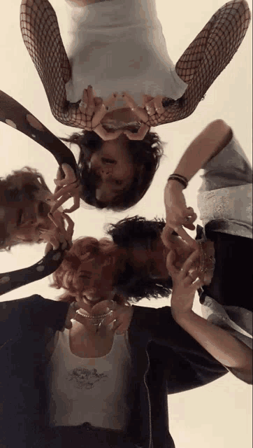 a group of people are standing in a circle with their heads in the middle