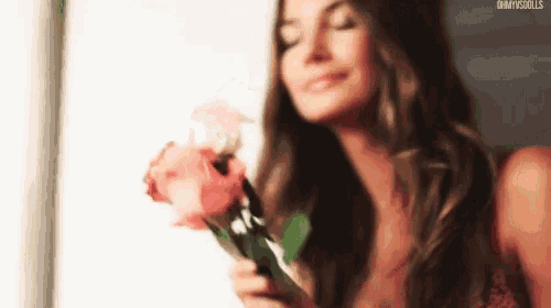 a woman is holding a bouquet of pink roses