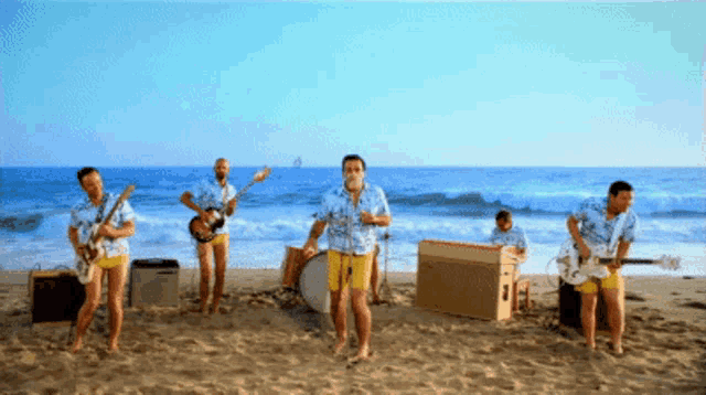 a group of men playing instruments on the beach