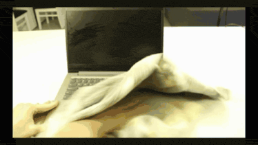 a laptop is being wiped with a cloth on a table