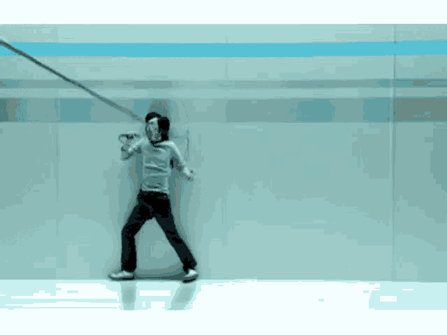 a man is leaning against a wall while holding a sword .