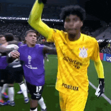 a soccer player wearing a yellow jersey that says fox lux