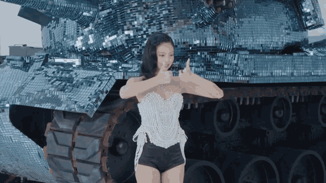 a woman giving a thumbs up in front of a tank made of mirrors