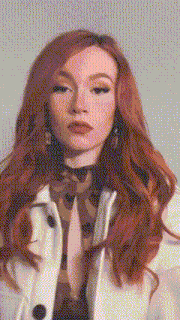 a woman with red hair is wearing a white coat .