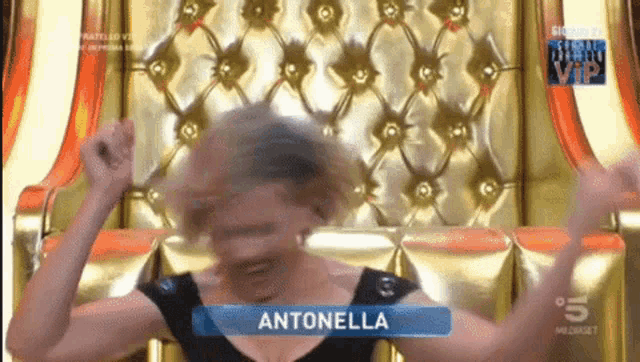 a woman named antonella is sitting in front of a gold chair
