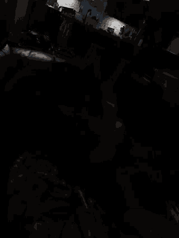 a dark room with a few lights on and a person standing in the corner