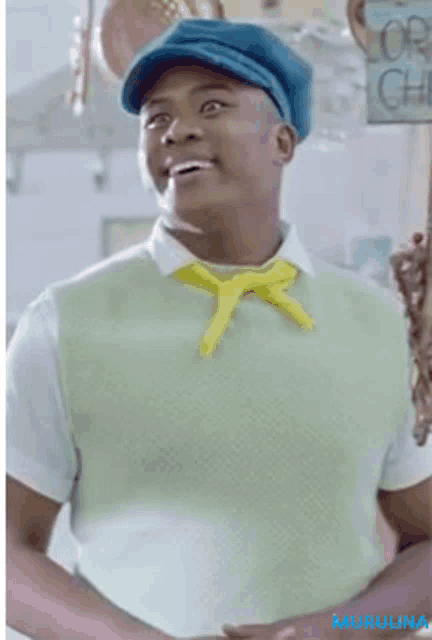 a man wearing a blue hat and a green vest with a yellow tie