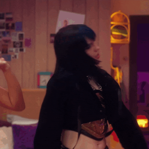 a woman in a crop top is dancing in a room