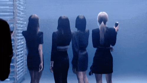 a group of women standing next to each other with one holding a phone