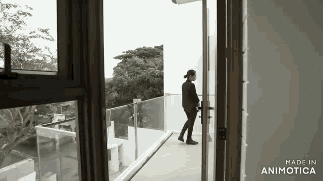 a woman standing on a balcony with the words made in animotica below her