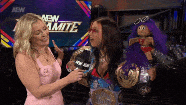 two women are standing in front of a screen that says aew