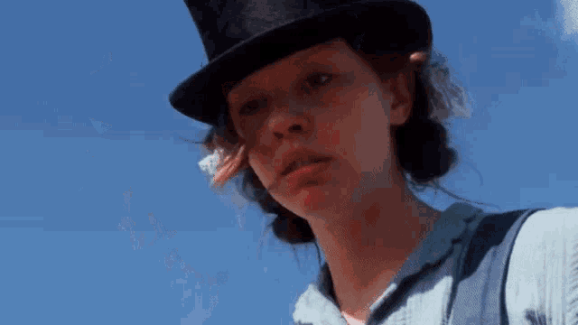 a woman wearing a top hat and a blue shirt says i 'm married