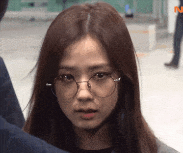 a close up of a woman wearing glasses with the letter n visible