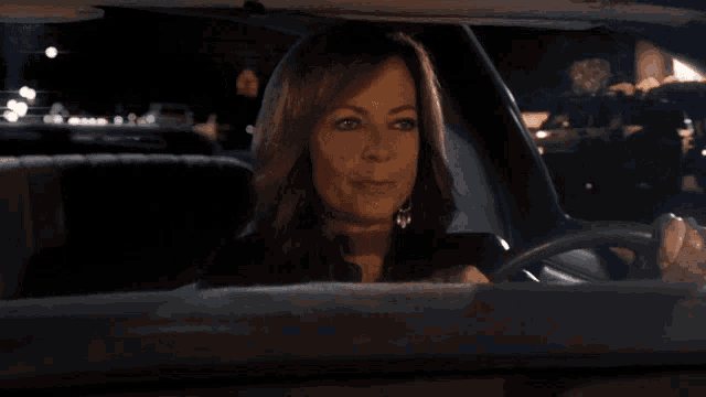 a woman sitting in a car with the words so what is it below her