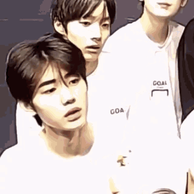 a group of young men are standing next to each other and looking at the camera .
