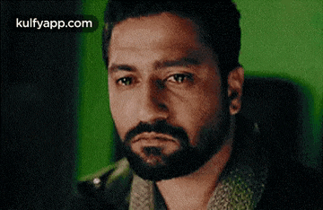 a man with a beard is making a sad face .