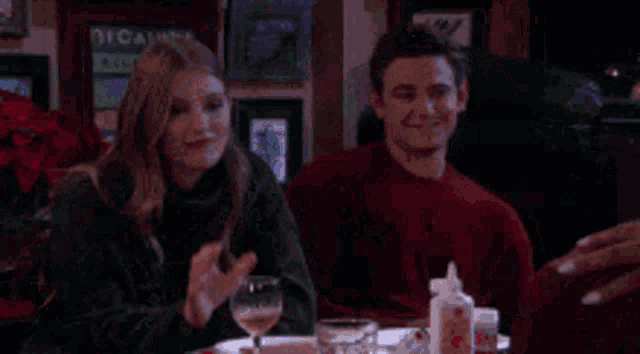 a man and a woman are sitting next to each other at a table .