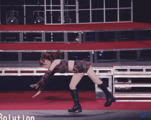 a woman is dancing on a red carpet with the words solution ms on the bottom right