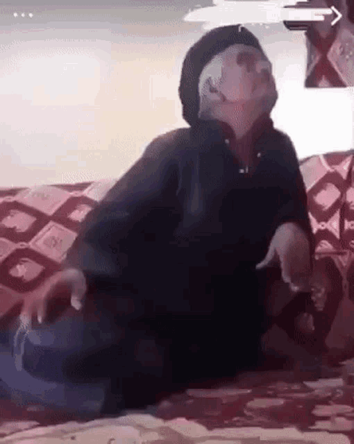 a person is sitting on a couch with their legs crossed and their arms outstretched .