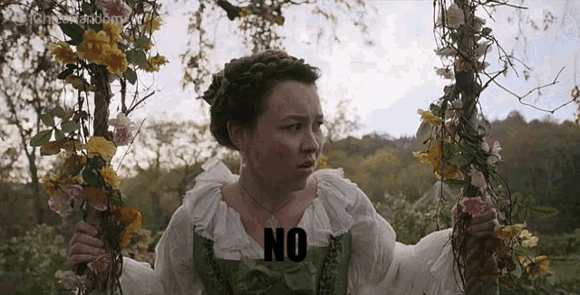 a woman is holding a swing with flowers on it and the word no is on the swing .