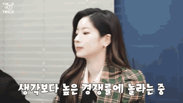 a woman in a plaid jacket with korean writing on the bottom