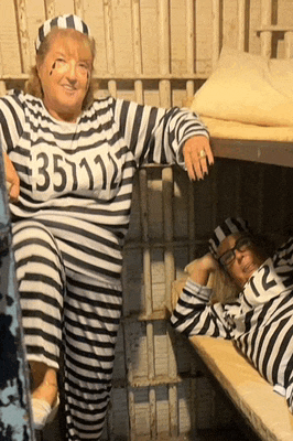 a woman in a striped prison uniform has the number 3511 on her chest