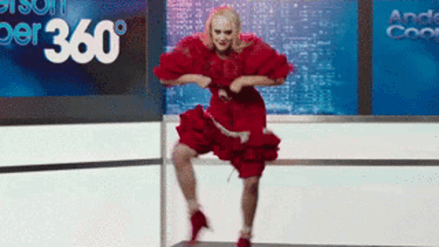 a woman in a red dress is dancing in front of a screen that says 360 degrees