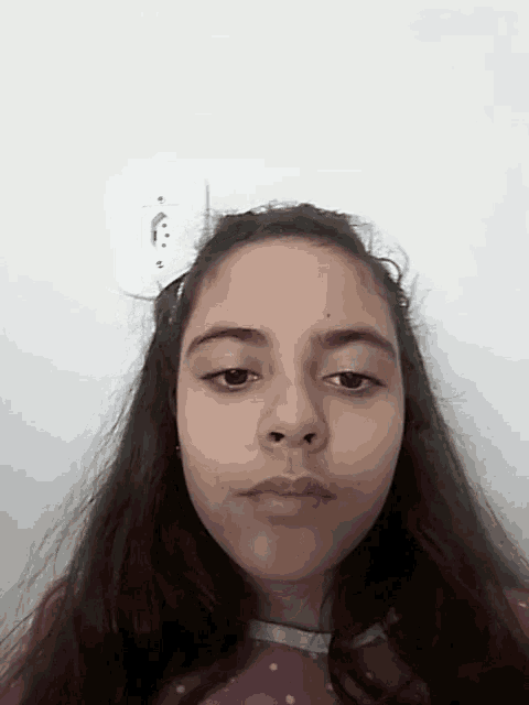 a girl in a purple dress looks at the camera