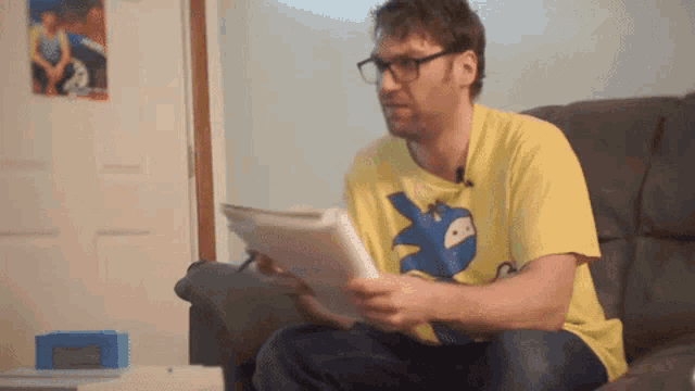a man wearing glasses and a yellow shirt with a sonic the hedgehog on it