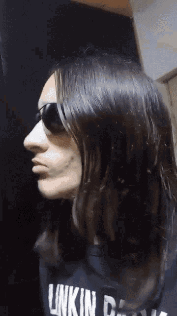 a woman wearing sunglasses and a black shirt with the word linkin on it