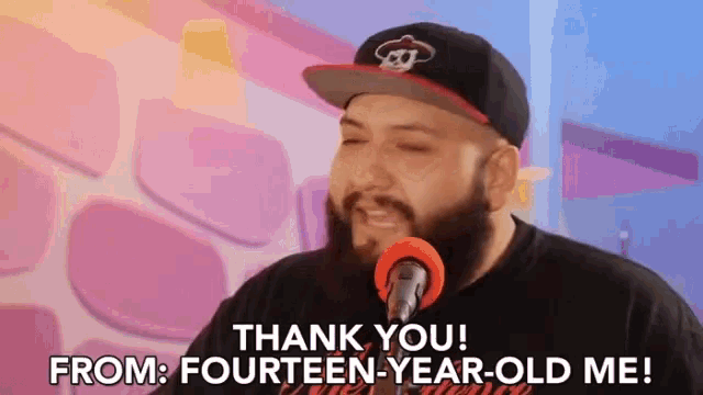 a man singing into a microphone with the words thank you from fourteen-year-old me