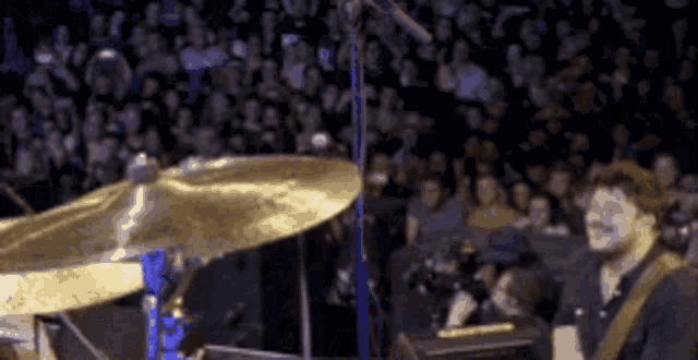 a man is playing a drum set in front of a crowd