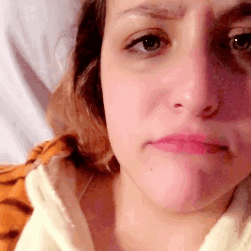 a close up of a woman 's face making a sad face