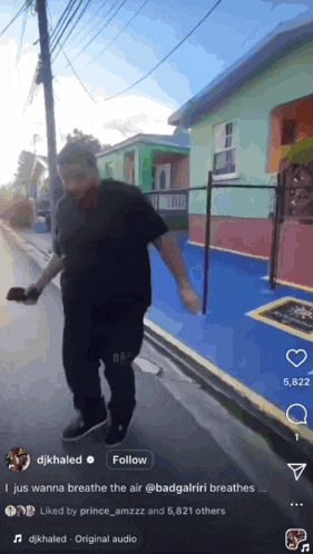 a man is walking down a street with a follow button on the bottom right