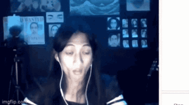 a woman wearing headphones is making a funny face in front of a wall with wanted posters