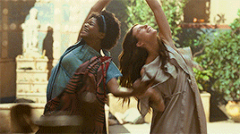 two women are dancing with their arms outstretched
