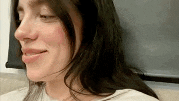 a close up of a woman 's face with her eyes closed and a smile on her face .