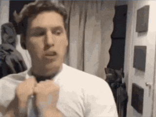 a man in a white shirt and tie is adjusting his tie .