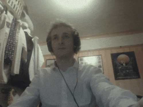 a man wearing headphones is taking a selfie in a room