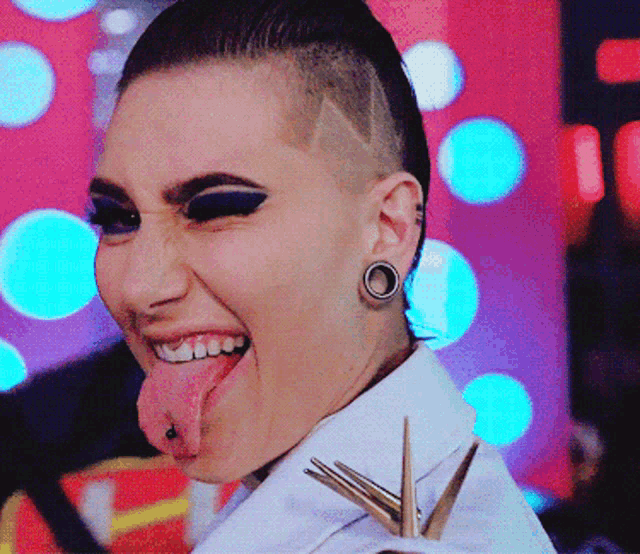 a woman with a shaved head has her tongue stuck out