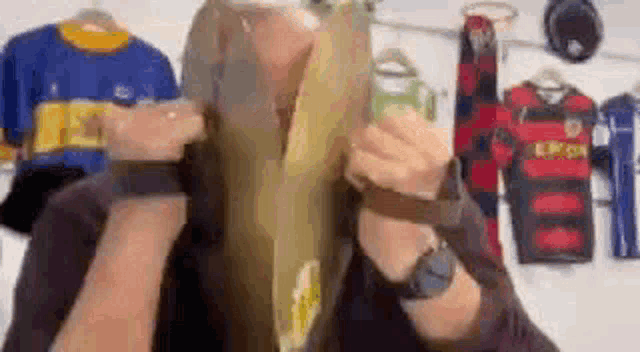 a woman is holding a piece of paper in front of her face in a store .