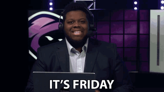 a man in a suit and headphones is sitting in front of a laptop and says it 's friday