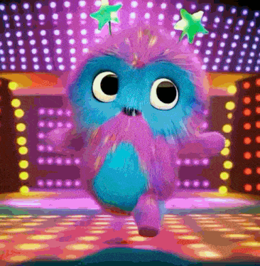 a blue and pink stuffed animal is dancing on a stage