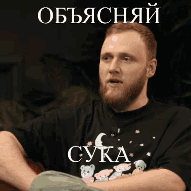 a man with a beard wears a black shirt that says cuka on it