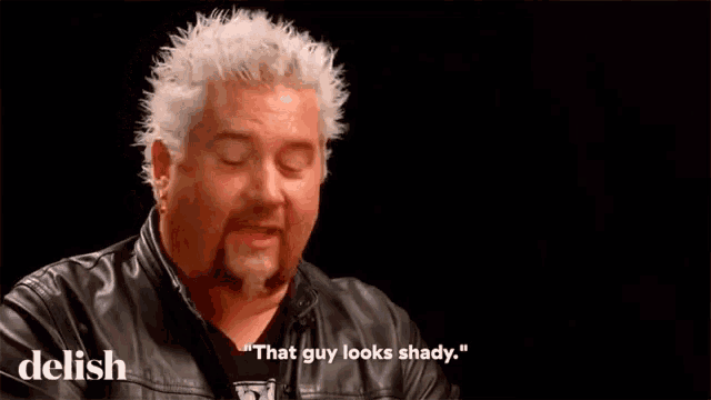 a man is making a funny face and saying that guy looks shady