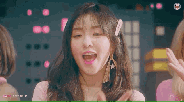 a close up of a girl with her mouth open and a star earring
