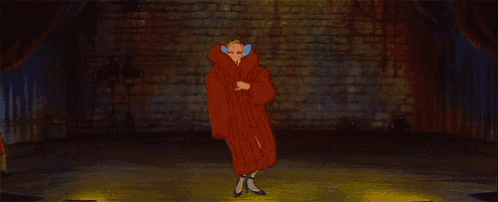 a woman in a white dress and blue tie is standing in front of a brick wall in a dark room