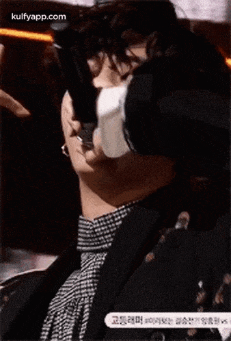 a man in a suit is covering his face with a piece of paper .
