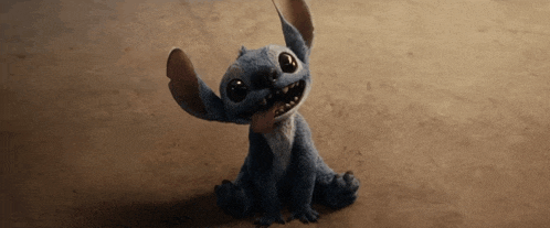 a stuffed animal is sitting on the ground and looking at the camera
