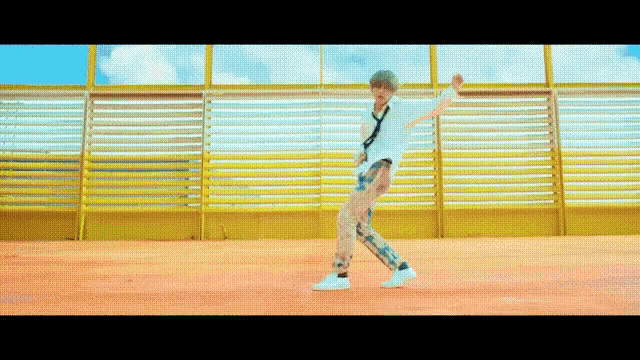 a man is dancing on a red floor in front of a yellow wall .